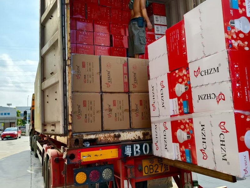 CHZM container loading inside truck with red and white product boxes